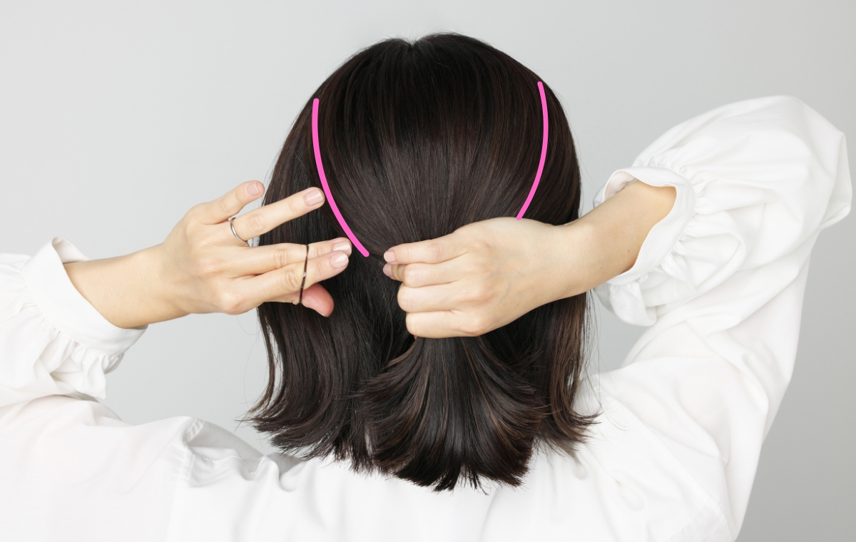ボブヘアのモデルが髪の上半分をまとめて結んでいる写真