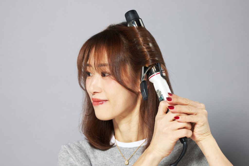 コテでリバース巻きにしているモデルの写真