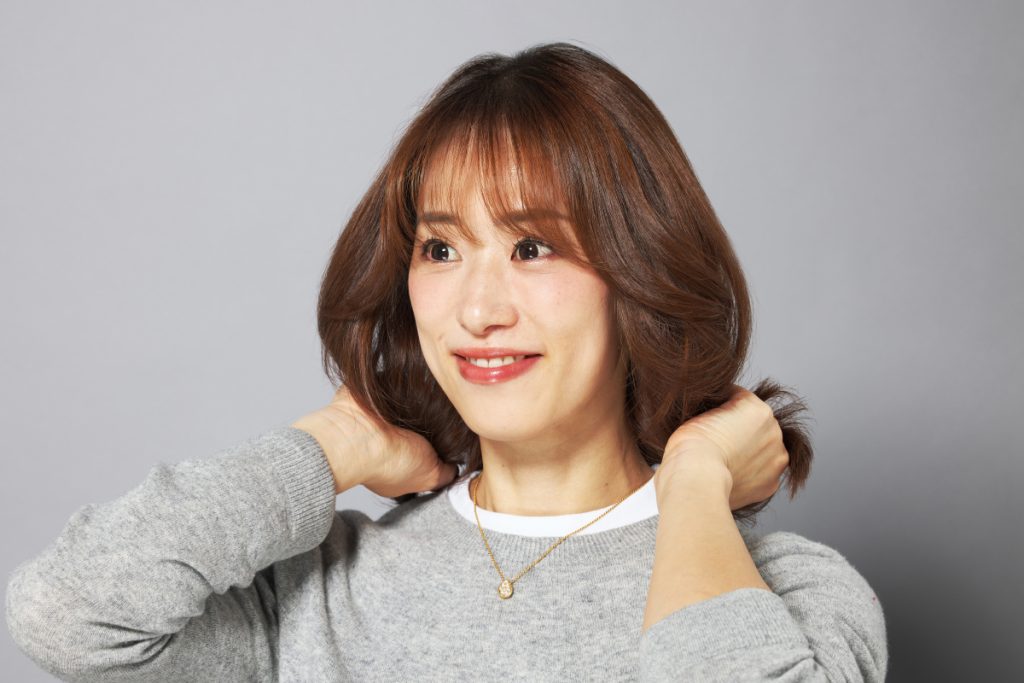 ヘアオイルをなじませているモデルの写真