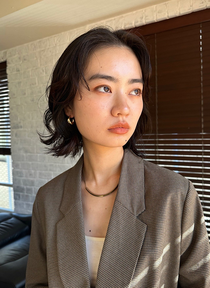 前髪なしのウェーブがかかったボブヘアの写真