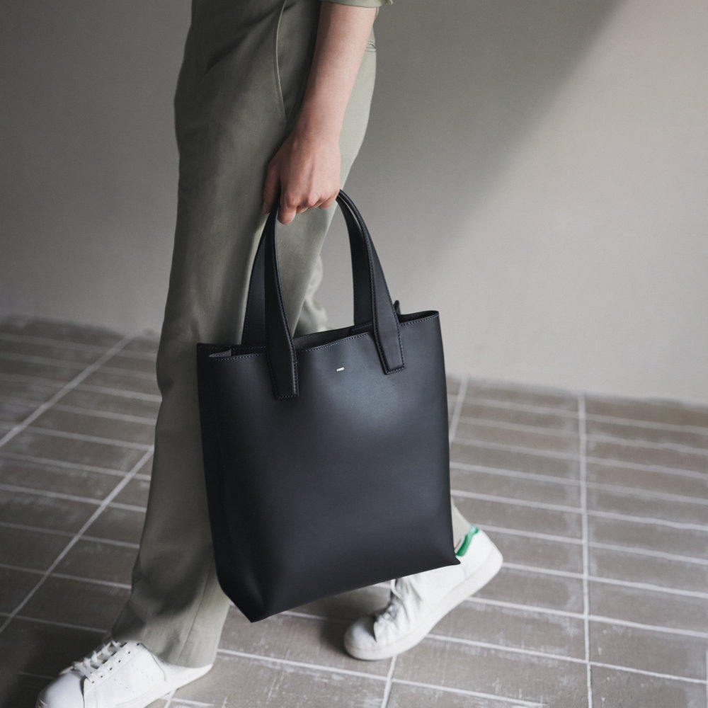 黒のトートバッグを持っている人の写真