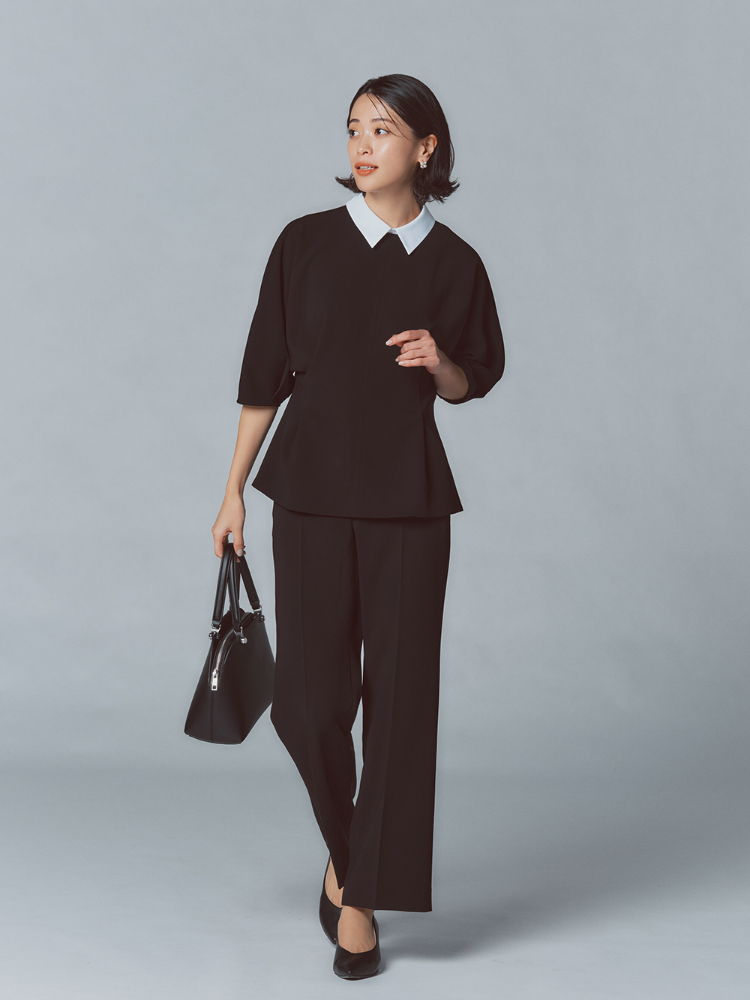 ネイビーブラウスとストレートパンツを着用したモデルの写真