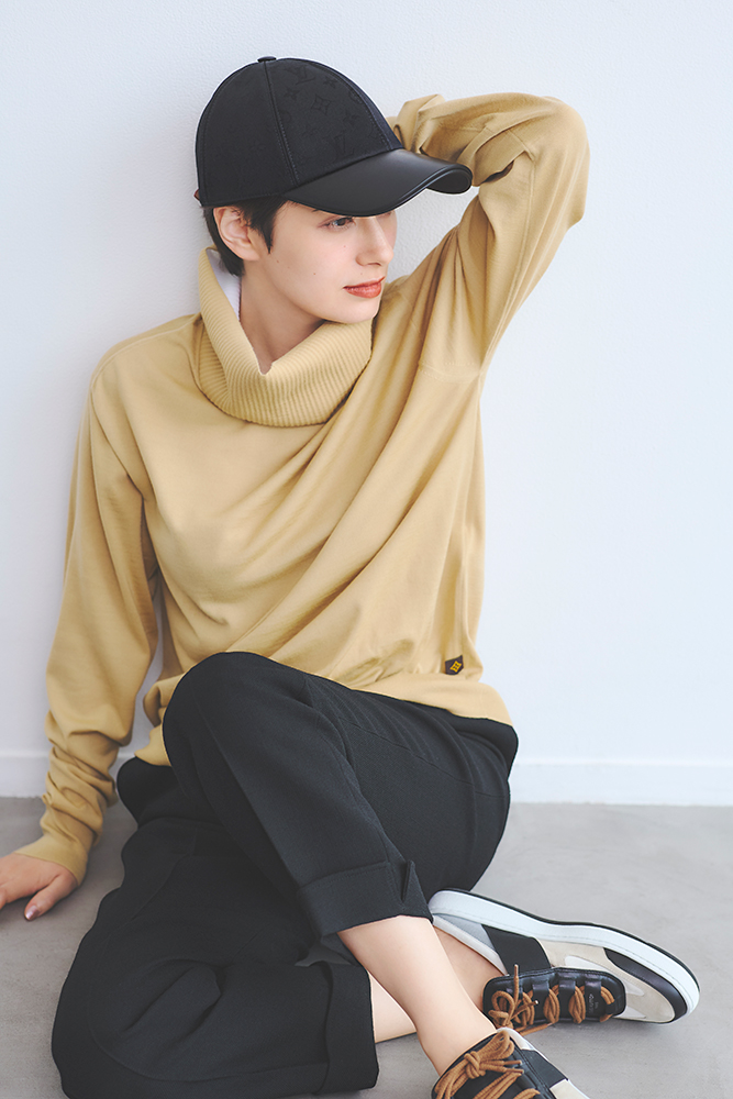 ホラン千秋さんのキャップ・パンツ・ニットコーデ 座ったポーズ