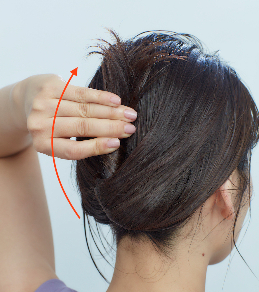 上品まとめ髪・ねじった毛束を後頭部へ沿わせている写真