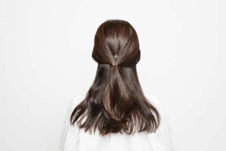 両サイドの耳前の髪を後ろでひとつにまとめた後頭部写真