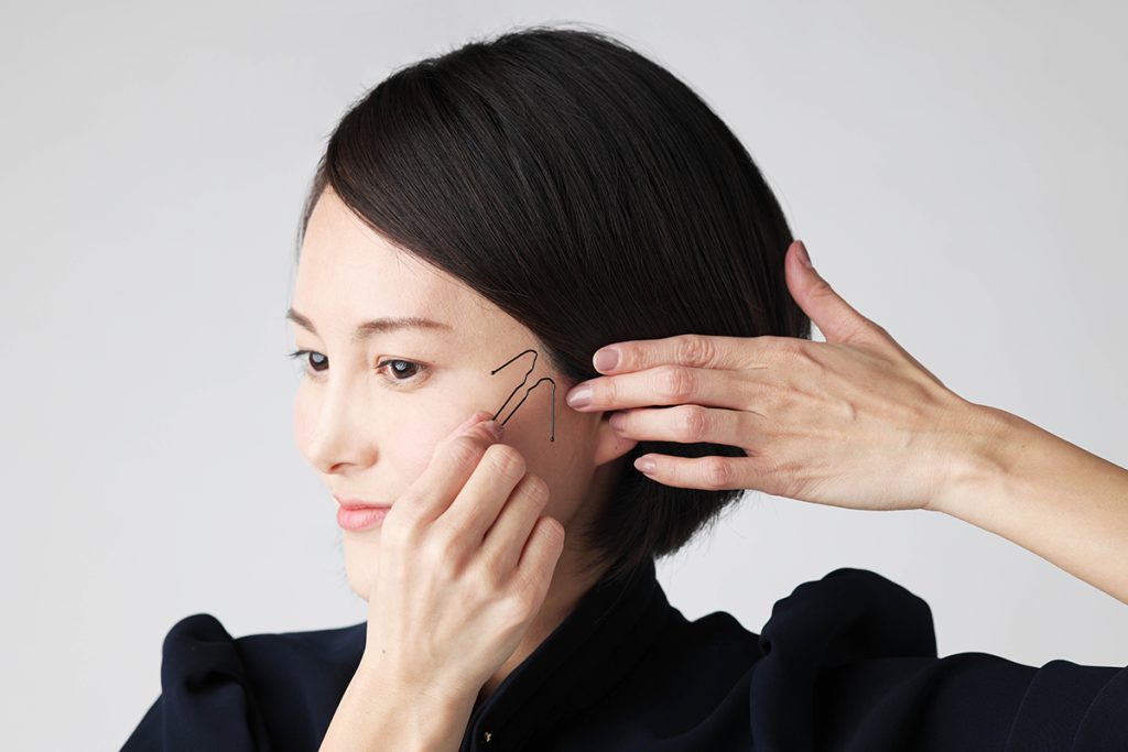 横流し前髪の内巻きヘア・ピンを挿している写真