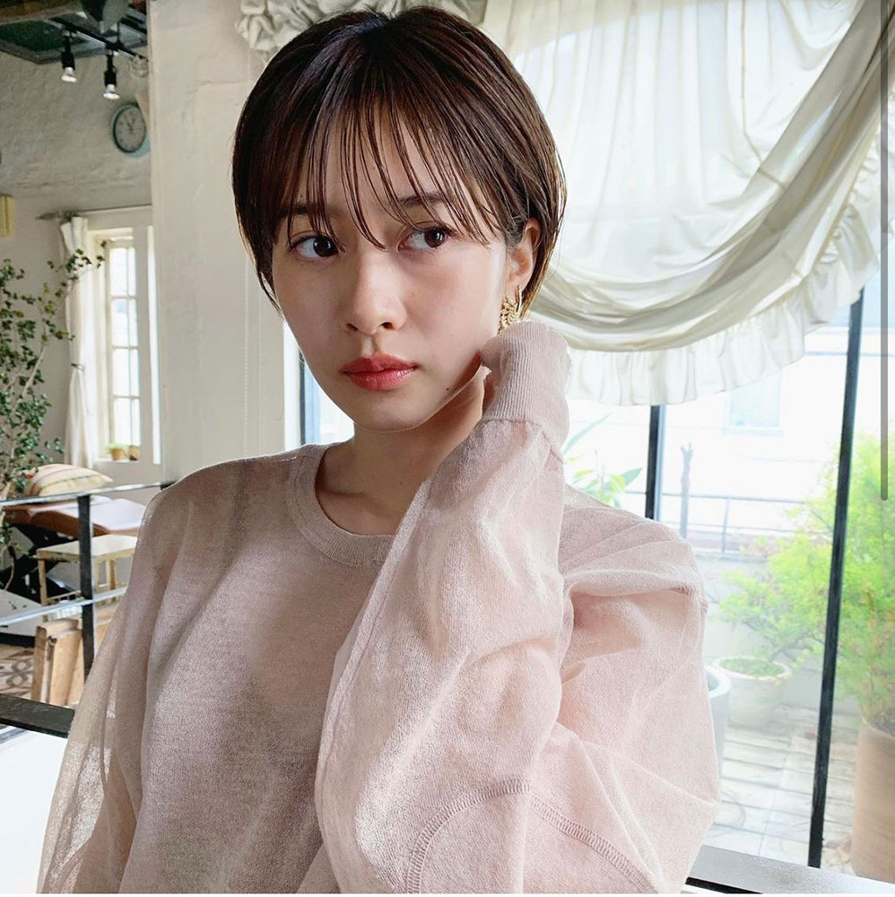 顎に手を当てたショートカットの女性