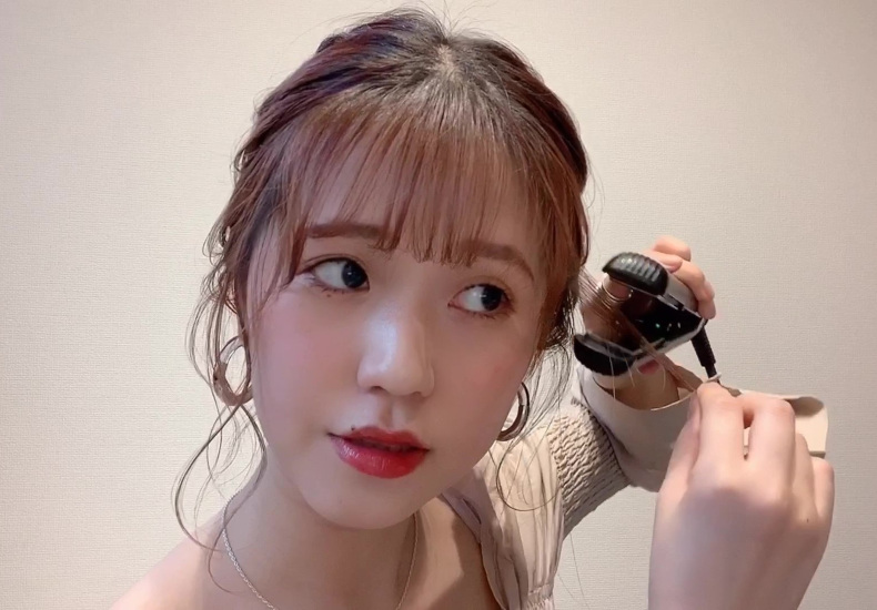 後れ毛をヘアアイロンで巻いている写真