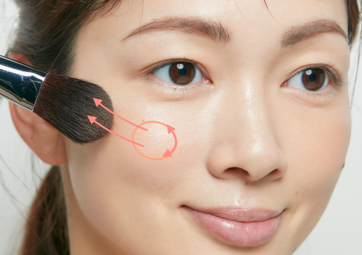 ブラシを使ってチークを頬にのせている様子