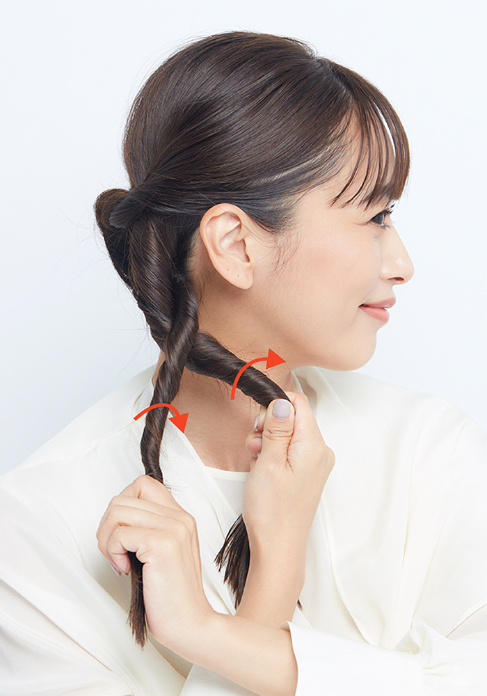 2本の毛束をねじり合わせている横顔写真