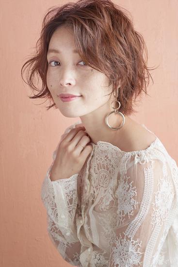 前髪なしでパーマがかかったショートヘアのモデル写真　横顔