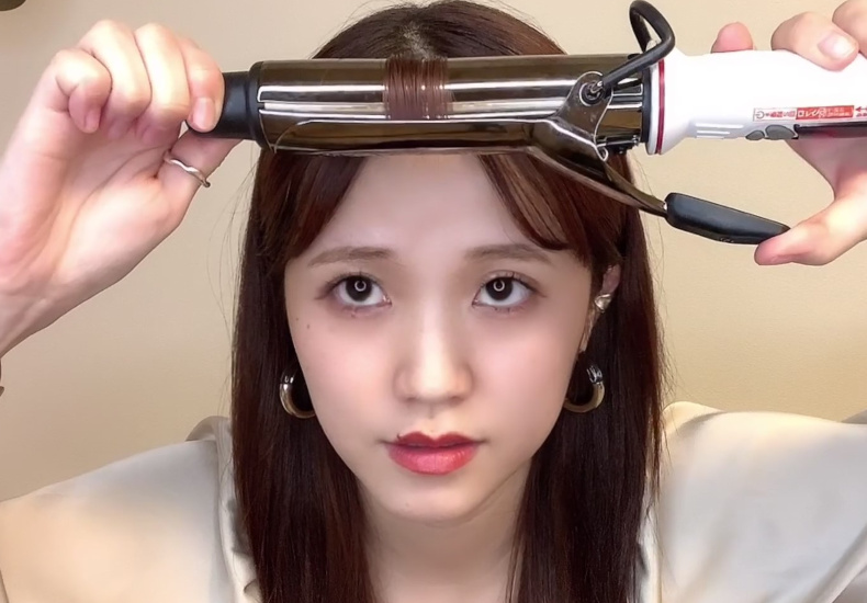 前髪をコテで巻いている写真