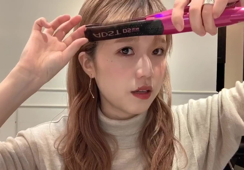 3つに分けたうちのサイドの毛束をアイロンで巻いている写真