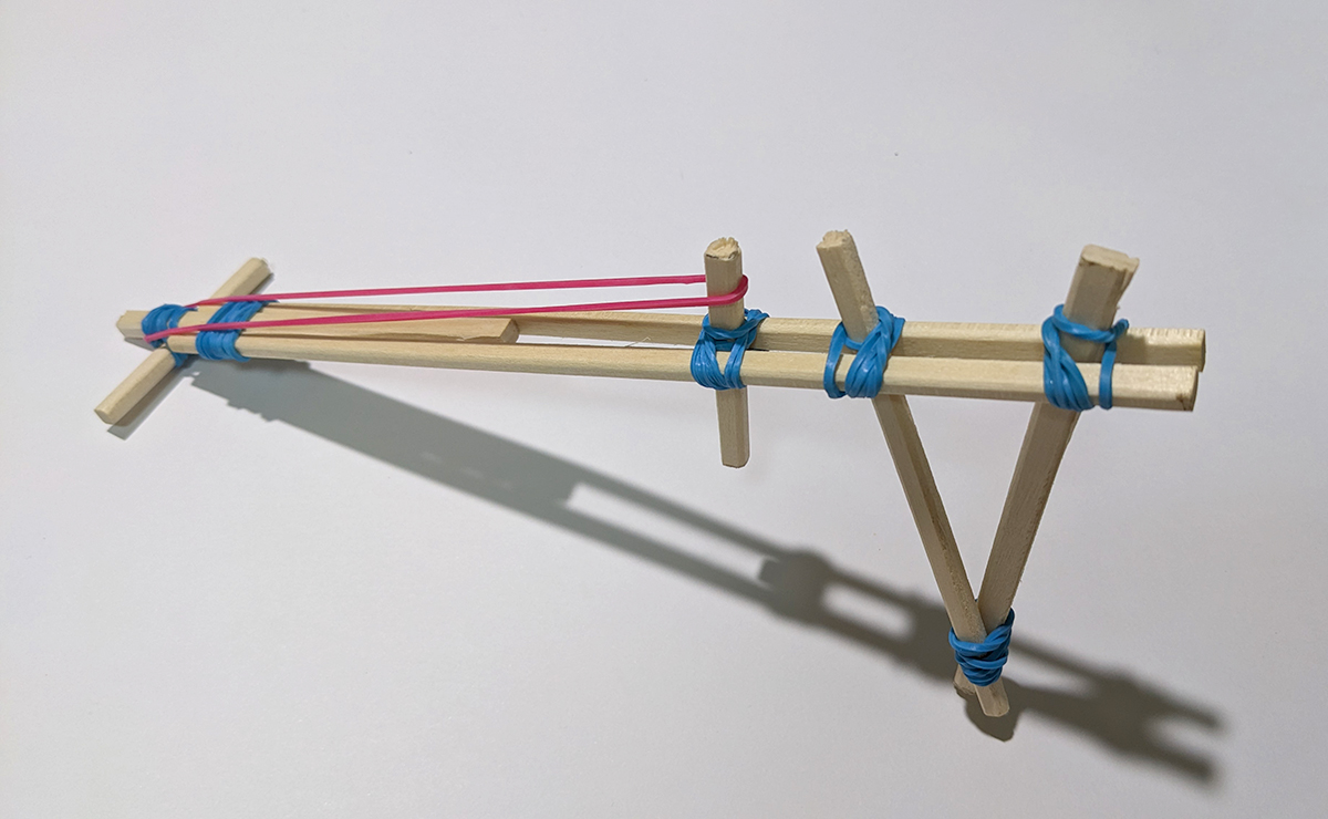 ピンクのゴムがセットされた割りばし鉄砲の写真