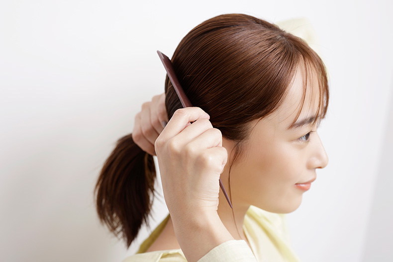 コームで髪を整えている写真