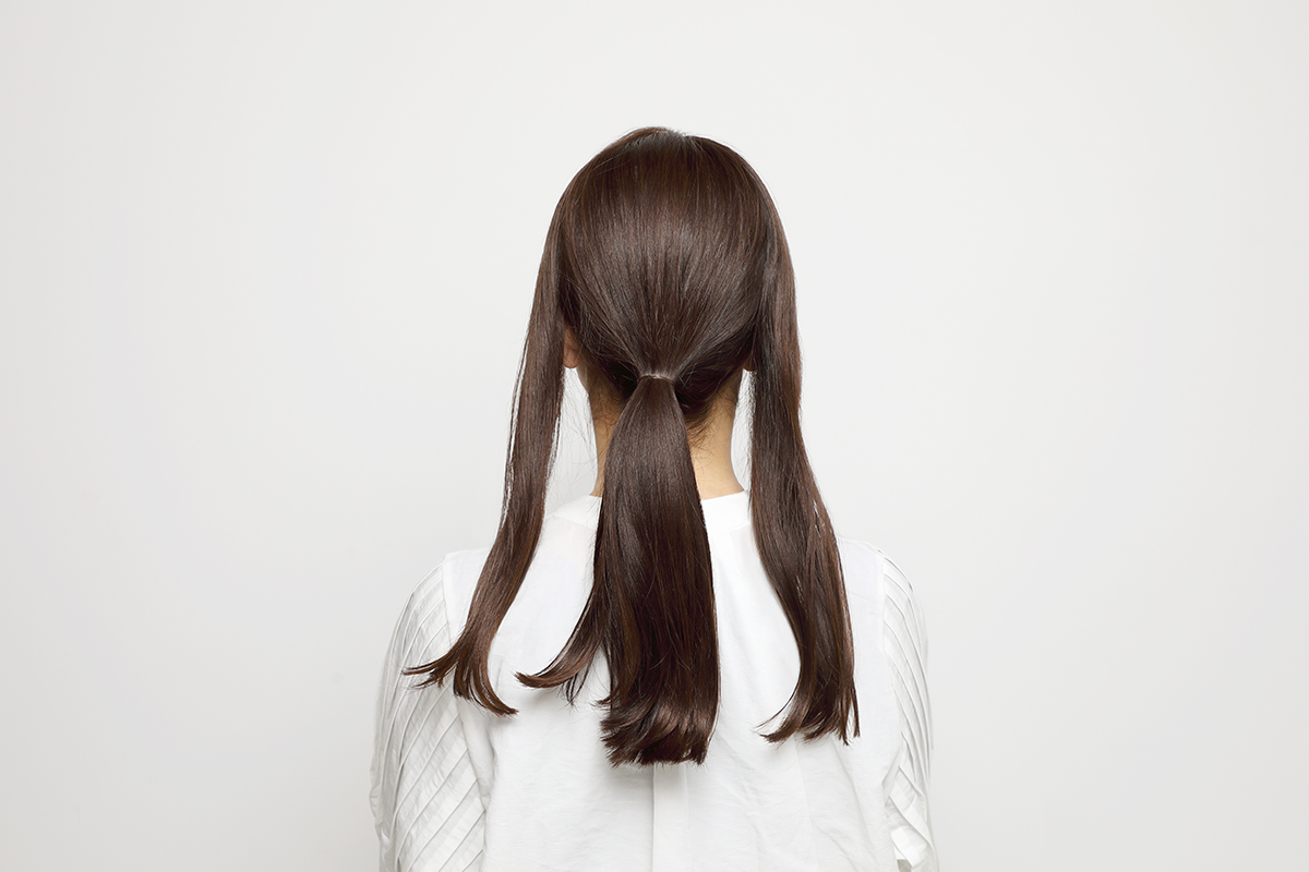 中心の髪だけひとつ結びにした後頭部写真