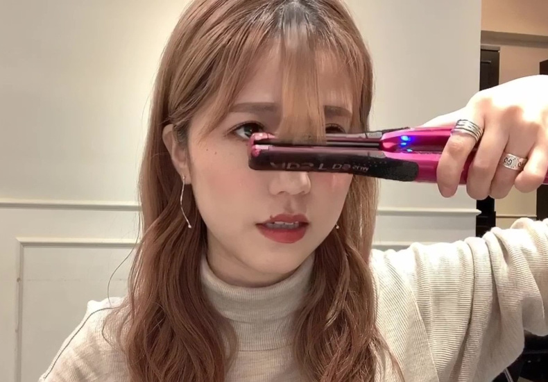 3つに分けたうちの真ん中の毛束をアイロンで巻いている写真