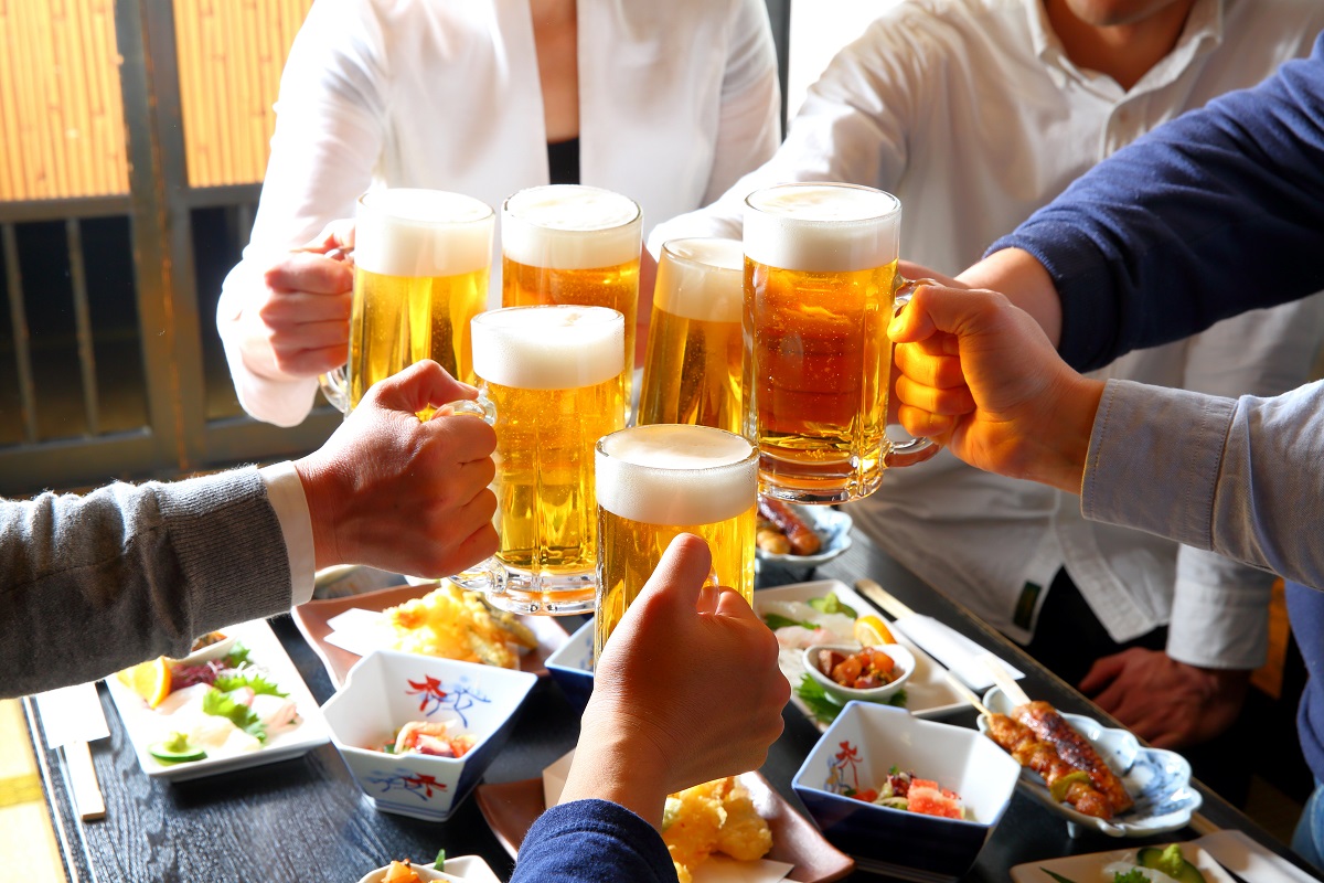 ビールジョッキで乾杯している人々の手元