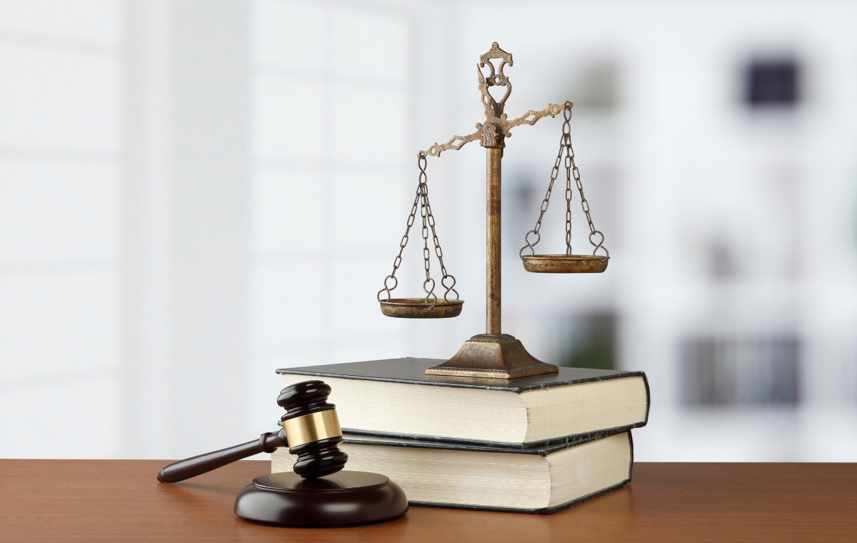 法律をイメージした木づちと天秤、法律書の写真