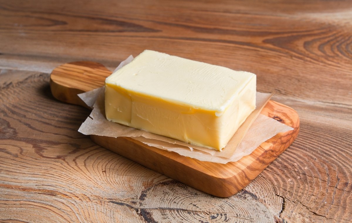 木のまな板にバターが置かれている写真