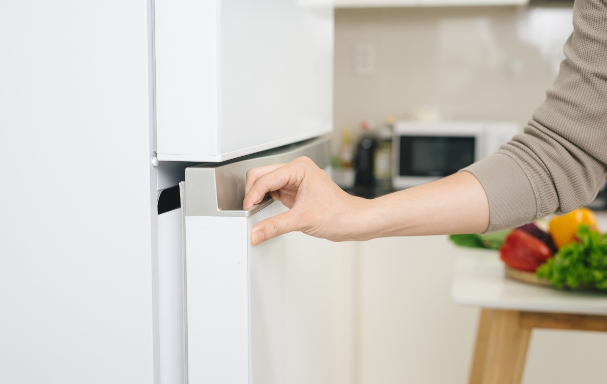 冷蔵庫を開けようとしている手元の写真