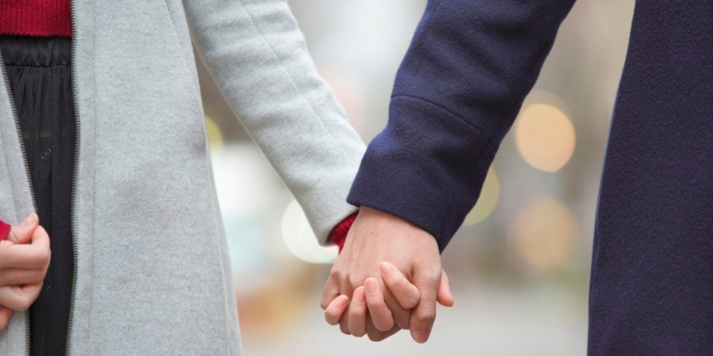 手をつなぐカップルの写真