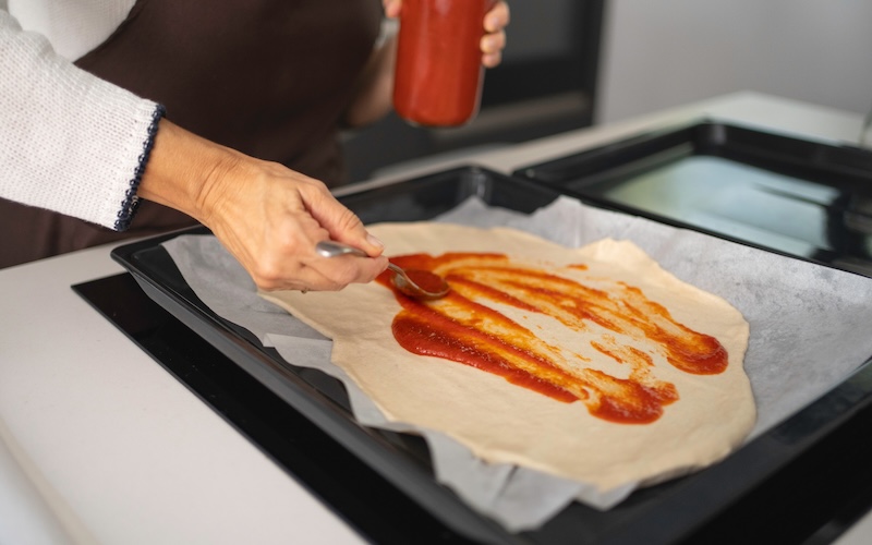 生地に赤いソースを塗っている写真