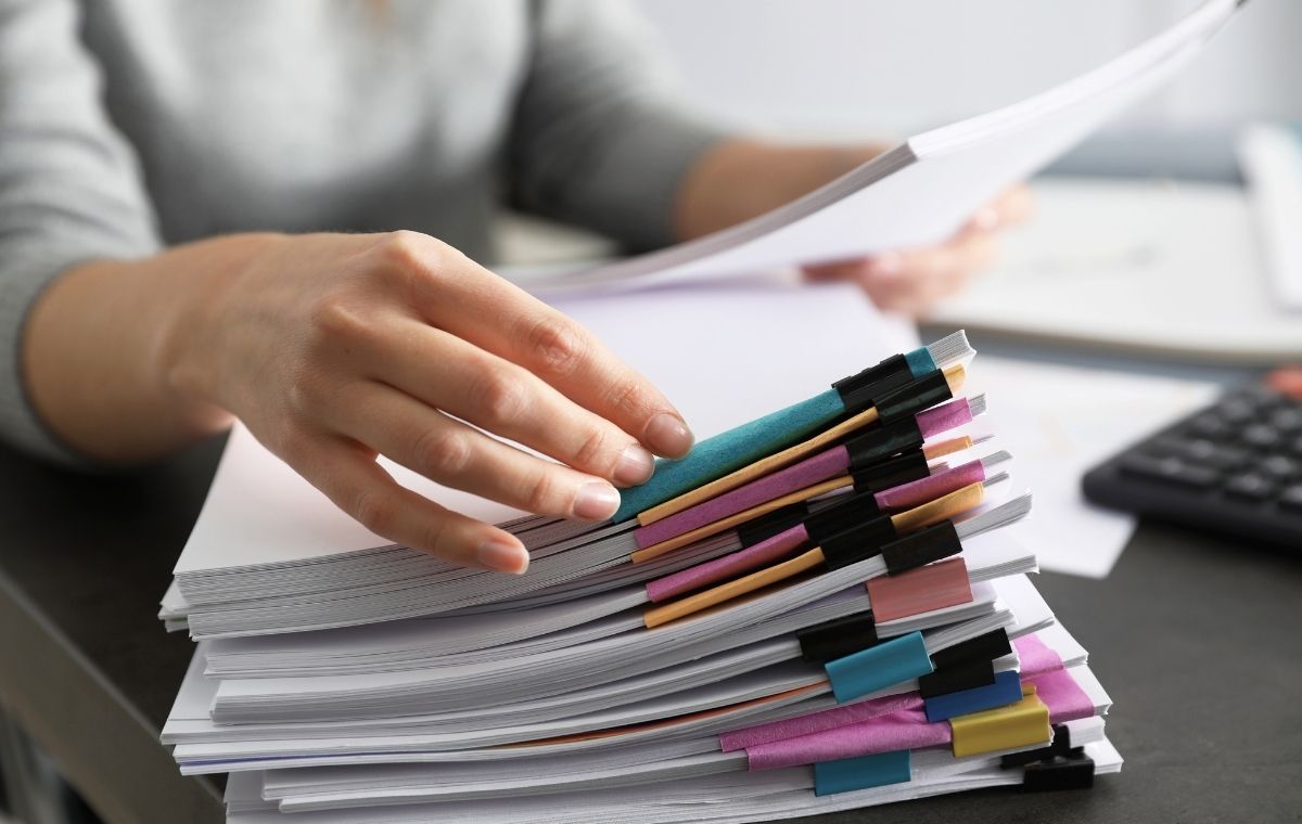 膨大な書類を処理している人の写真