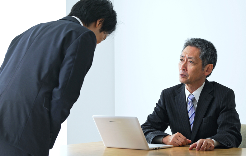上司に謝る部下の写真