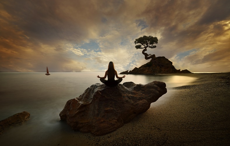 岩に座ってポーズをとる女性