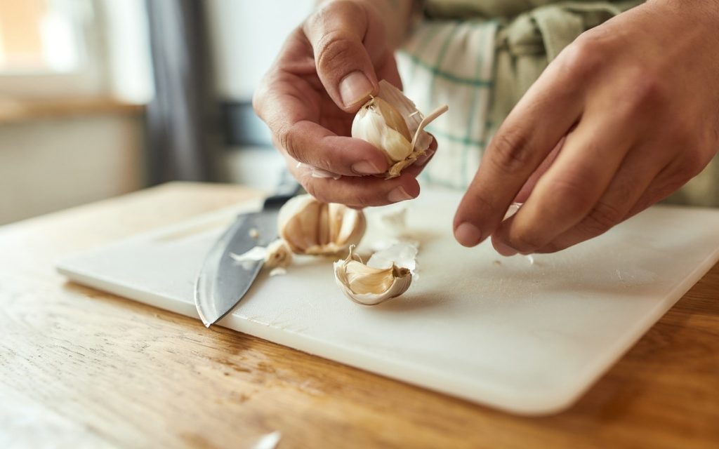 まな板でニンニクを切っている写真