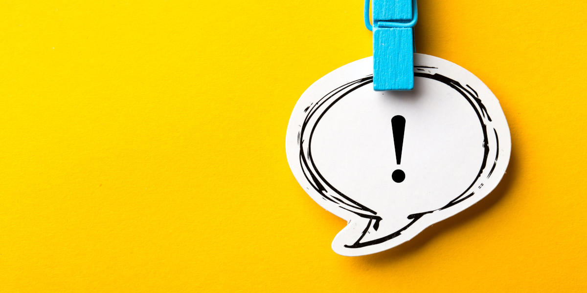 吹き出しの中に描かれたビックリマークがクリップで吊り下げられている写真