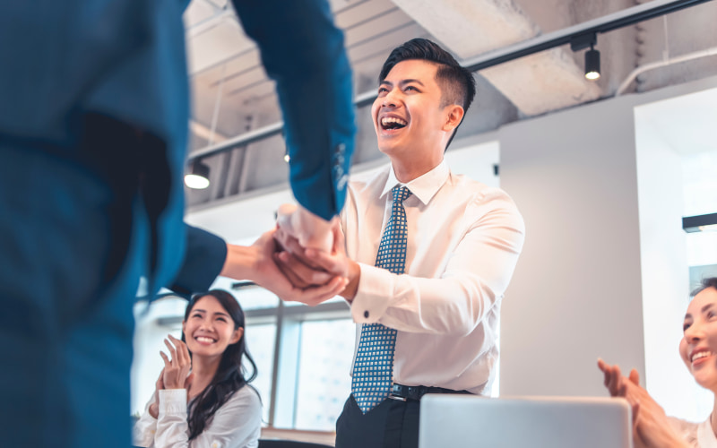 会議で拍手・激励を受けるビジネスマン