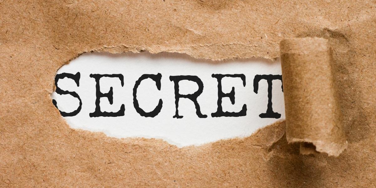 破られた紙の間からSECRETという文字がのぞいている写真