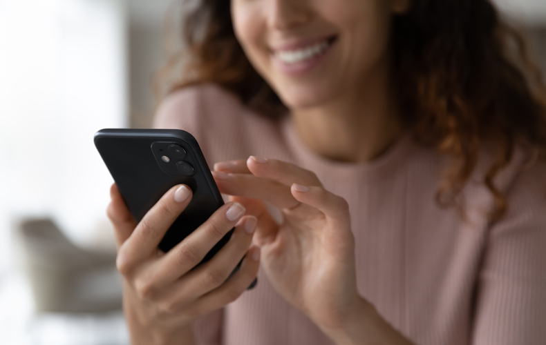 スマホをタップする女性の写真