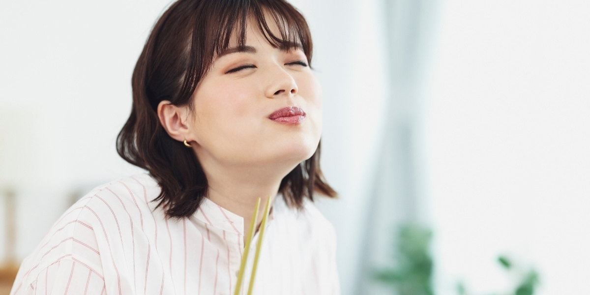 美味しそうに食事する女性の写真