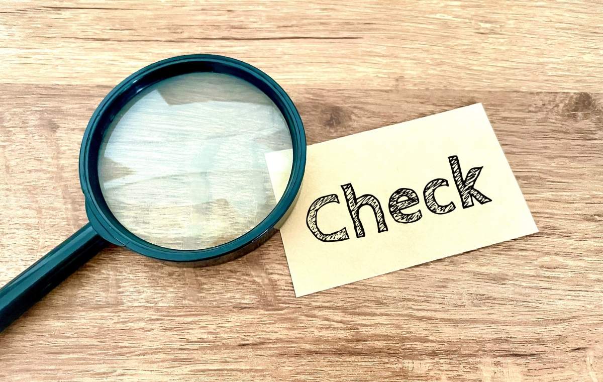 ルーペの下にcheckと書かれている紙が置かれた写真