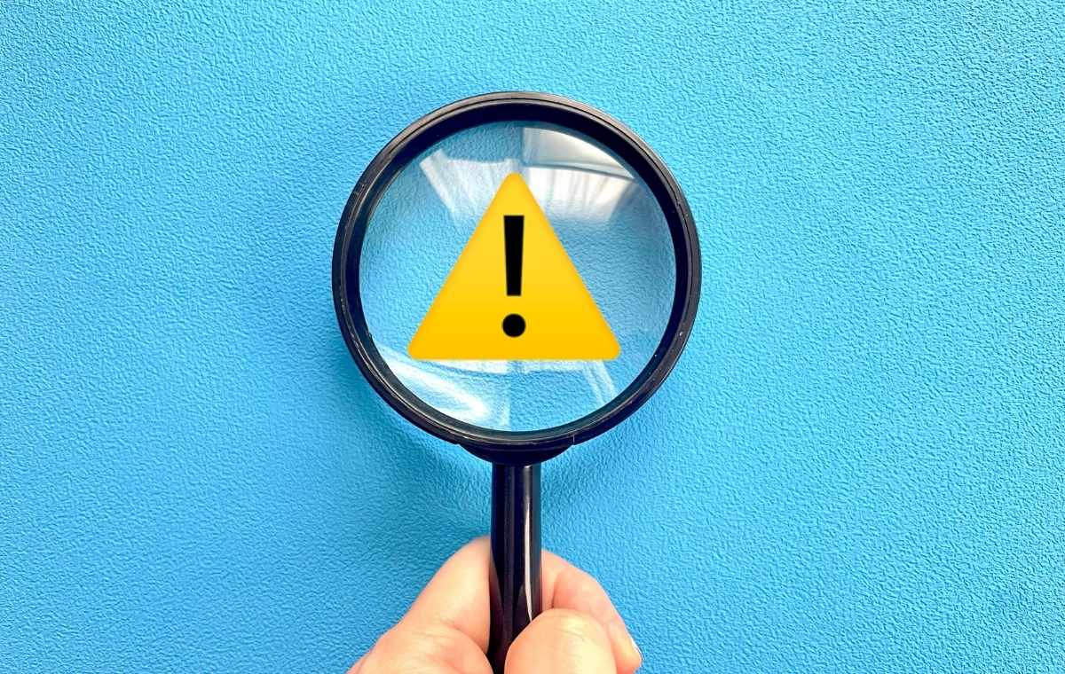 注意マークにルーペをあてている写真