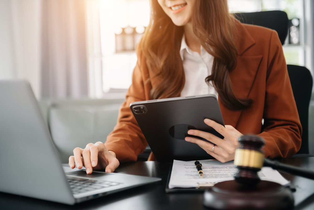 ノートパソコンとタブレットを操作している人の写真