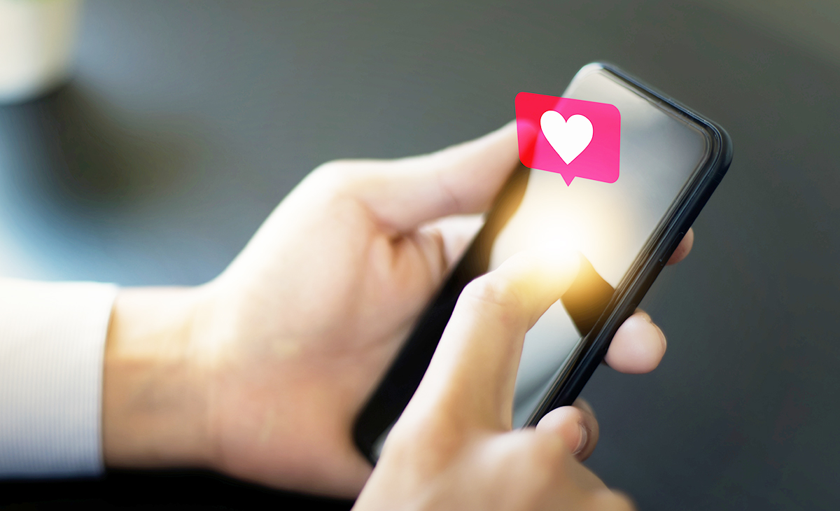 いいねをする女性の手とスマートフォン