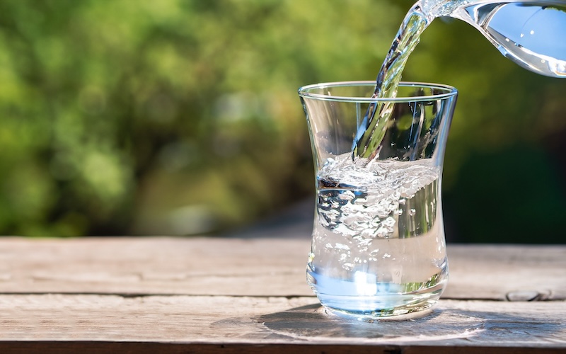 コップに注いでいる水の写真