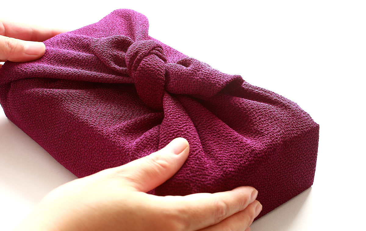 風呂敷で包んだ品物を受け取った様子