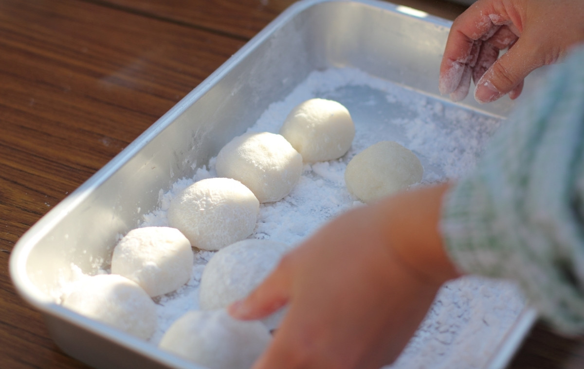 ついた餅をバットに並べている女性の写真