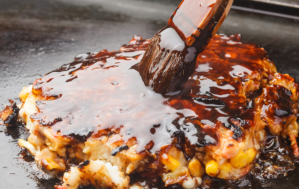 お好み焼きにソースを塗る様子