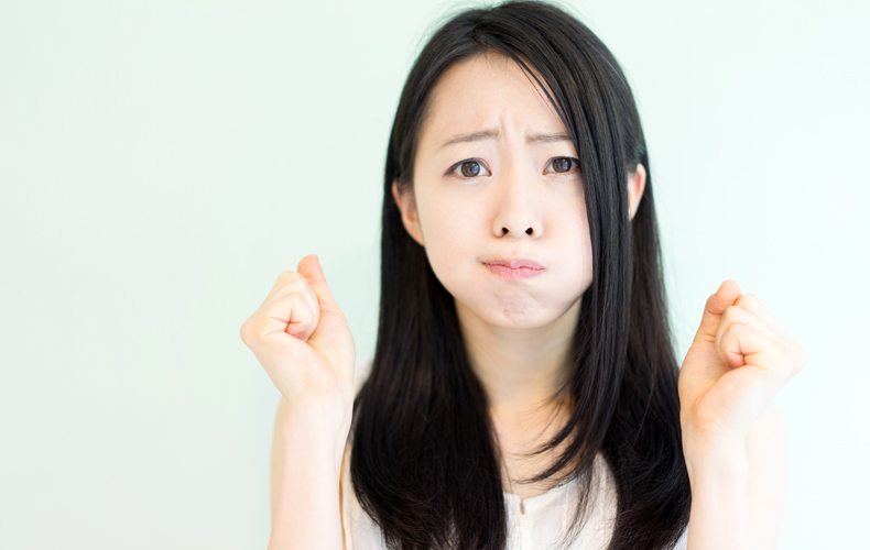 頬を膨らまし両手の拳を顔の位置まであげ、オーバーアクションをする女性