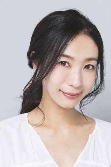 後れ毛にウェーブがかかった前髪なしひとつ結びの正面写真