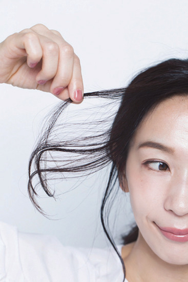 後れ毛に指先でバームをつけている写真