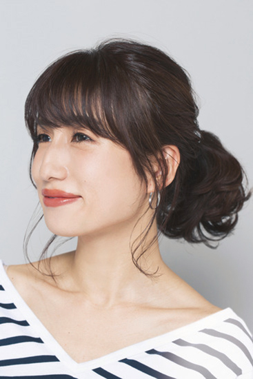 後れ毛にウェーブがかかったひとつ結びの横顔写真