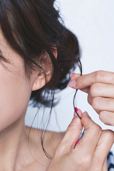 後れ毛に指先でシアバターをつけている写真