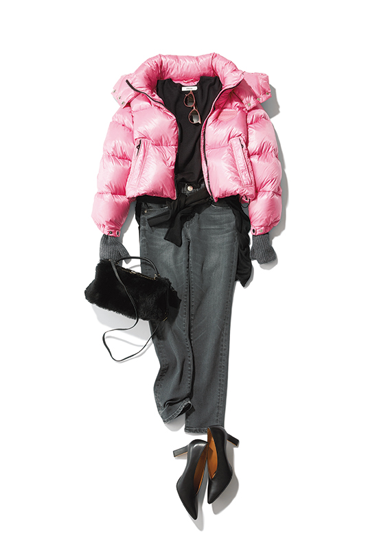 黒のニットとデニムパンツにピンクのショート丈のダウンをはおり、腰に黒のニットを巻いたコーデ写真